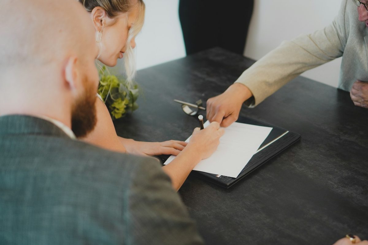 Couple examinant et signant un devis de travaux à une table de bureau