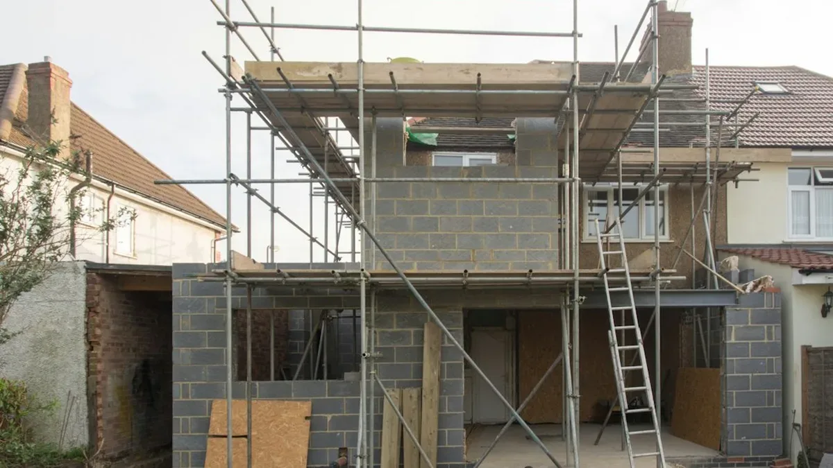 Extension de maison en construction, échafaudage et murs en parpaings
